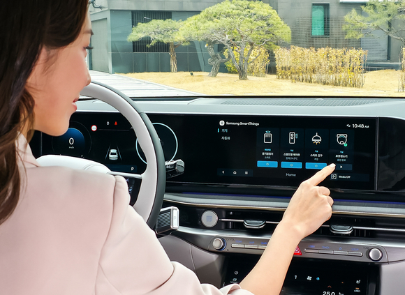 ▲삼성전자 모델이 차량에서 집 안 가전기기를 제어하는 '카투홈(Car-to-Home)' 서비스를 체험하고 있다. / 사진=삼성전자 삼성전자-현대차그룹, 카투홈 서비스 개시…차량서 가전 원격 제어